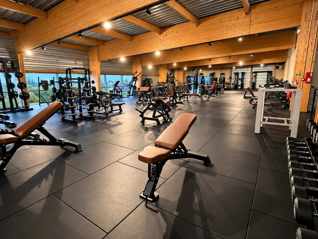Machines de musculation devant les grandes baies vitrées ouvertes sur la nature