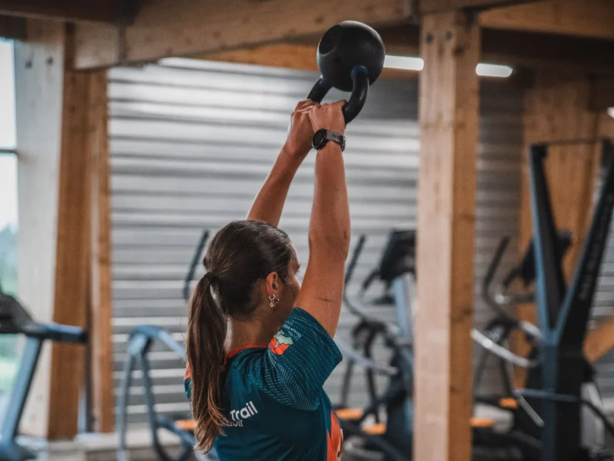 Une adhérente réalise un mouvement avec kettlebell dans l’espace HYROX